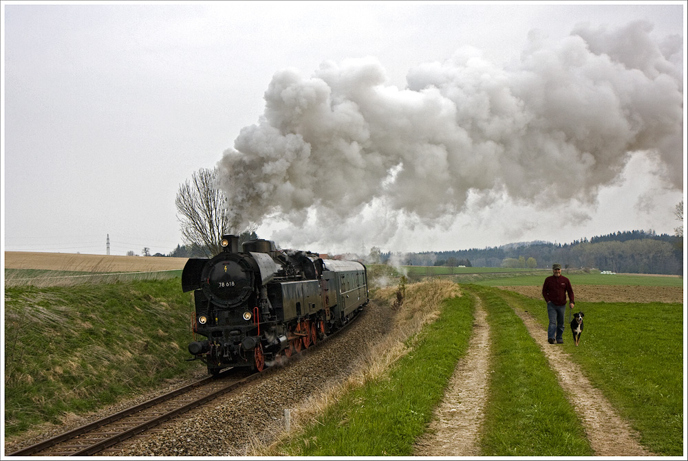 Unbeeindruckt war der Spaziergänger mit seinem Hund sicherlich nicht. Nur so eine Aufnahme ist in Echt kaum zu machen, denn da gibt es viele Fotografen die zum Schimpfen und zum laut Grüßen (HALLO!!) anfangen. So entsteht so eine Szene halt im Computer.
21.April 2010 - Fotofahrt mit der 78.618 auf der Strecke von Ried nach Attnang-Puchheim. Hier bei Oberbrunn!
