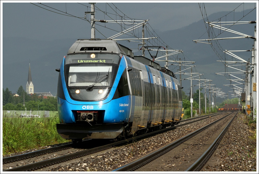 Und als die blaue Ente vorbeifuhr, kam f�r 2 Minuten die Sonne raus :O)
Unterwegs war der Triebwagen 4024 120 als R 4215 von Bruck an der Mur nach Unzmarkt.
Zeltweg 26.05.2010
