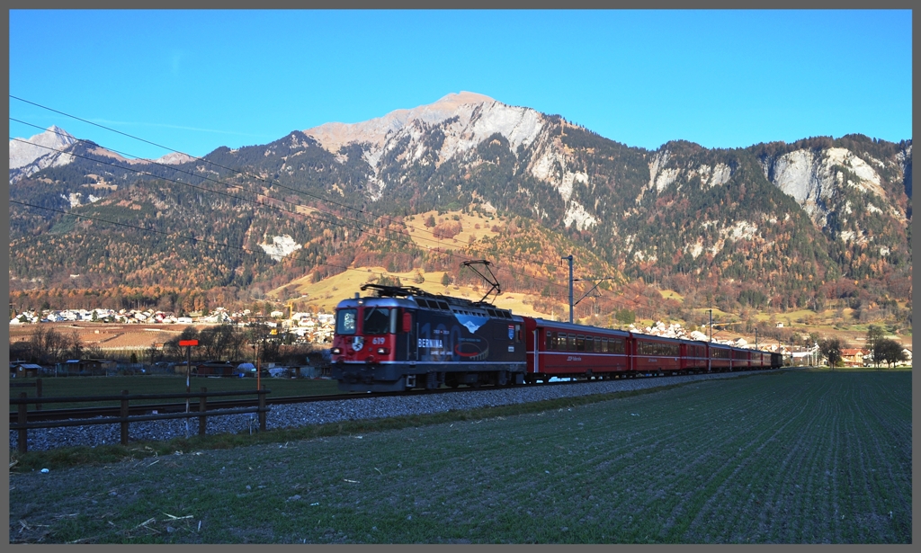 Und urpltzlich steht man unverhofft im Schatten. Schon kurz nach 15.00Uhr verschwindet die Sonne hinter dem Calandagipfel, whrenddem RE1244 mit Ge 4/4 II 619  Samedan  Landquart entgegeneilt. (30.11.2011)