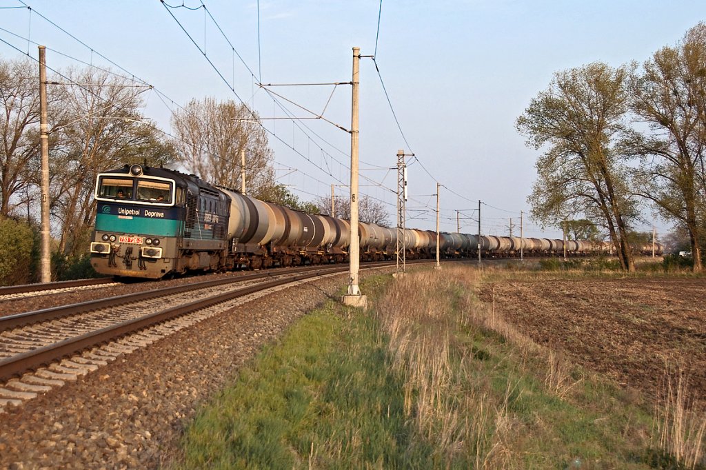  Unipetrol Doprava  753 720 wird mit ihrem Kesselwagenganzzug in wenigen Minuten den Hauptbahnhof in Breclav erreichen. Die Aufnahme enstand zwischen Lanzhot und Breclav, am 19.04.2011, als die Sonne schon ziemlich tief stand. 