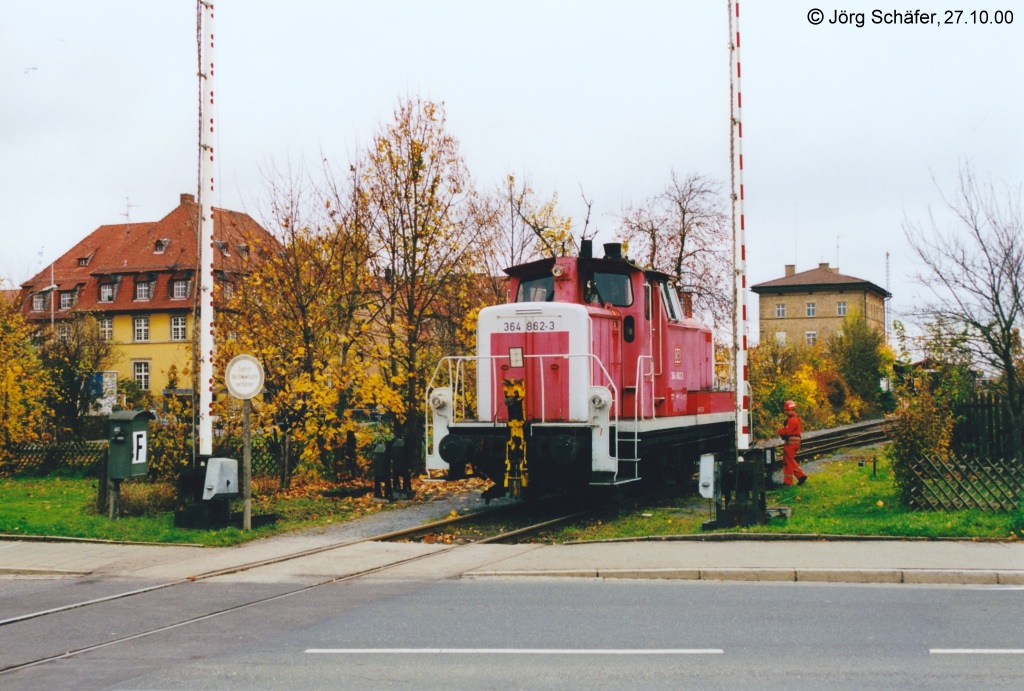 Unmittelbar neben dem Bahnhof liegt der viel befahrene Bahnbergang der Staatsstrae nach Neusitz. Da hier seit 1971 nur noch wenige Gterzge fahren, wurde er nicht automatisiert. Der Fahrdienstleiter muss zum Kurbelwerk laufen und die Schrankenbume per Hand schlieen. Erst dann darf der Zug die Strae berqueren. (27.10.00)

