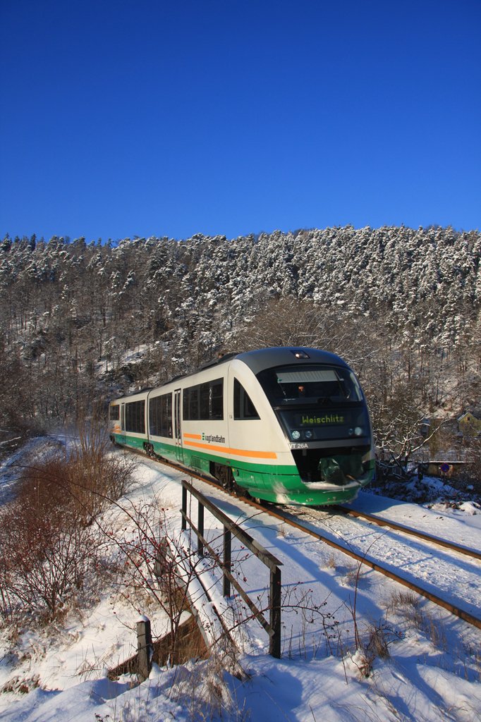 Unnatürlich blau zeichnet sich der Himmel hinter dem verschneiten Wald ab, als VT26 Berga/Elster erreicht. (83169 Gera Hbf - Weischlitz, 05.01.2010) 