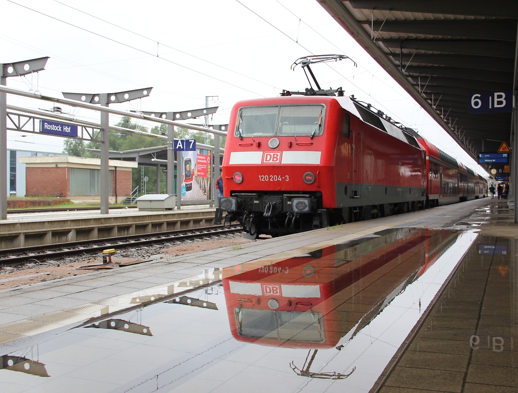Unser erster Ausflug nach Rostock und damit zur Hanse Sail stand am Freitag, den 12.08.2011, unter keinem guten Wetter-Stern. Sogar am Hbf war Land Unter. 120 204-3 mit dem RE aus Hamburg spiegelt sich in der Pftze am Gleis 6.