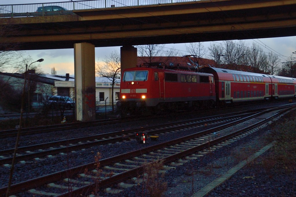 Unter der Straenbrcke ber die Kbs 485 in Korschenbroich befindet sich die 111 012 mit einem RE4 Dostock-Zug. 30.1.2012