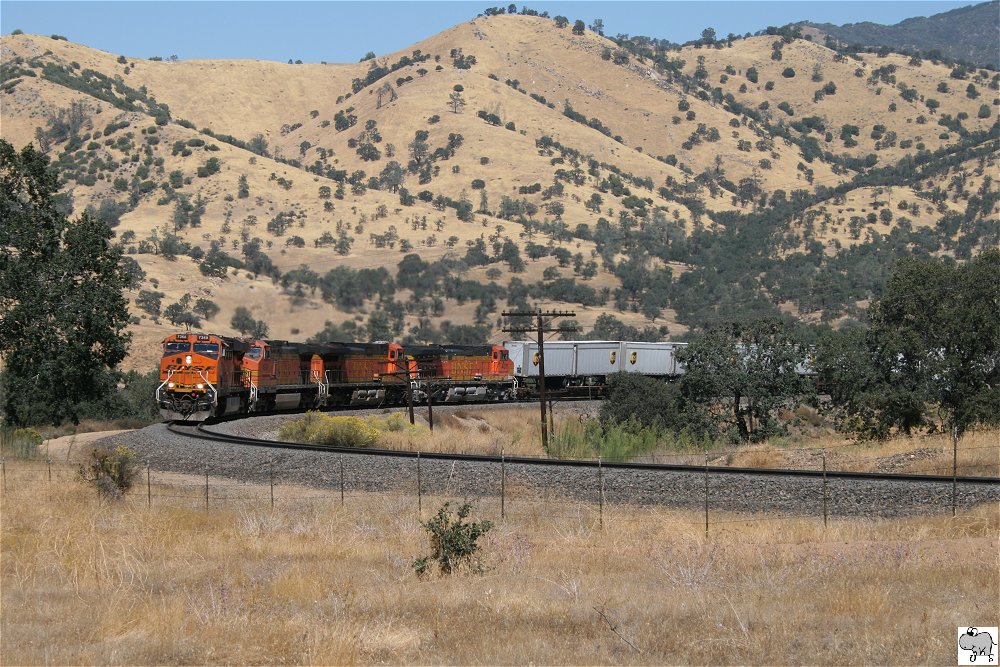 Unterhalb des Tehachapi Loop nhert sich ein bergauf fahrender Gterzug der BNSF. Gezogen von # 7368 (GE ES44DC), # 4080 (GE C44-9W), # 5232 (GE C44-9W)und # 4311(GE C44-9W). Kalifornien, September 2011.