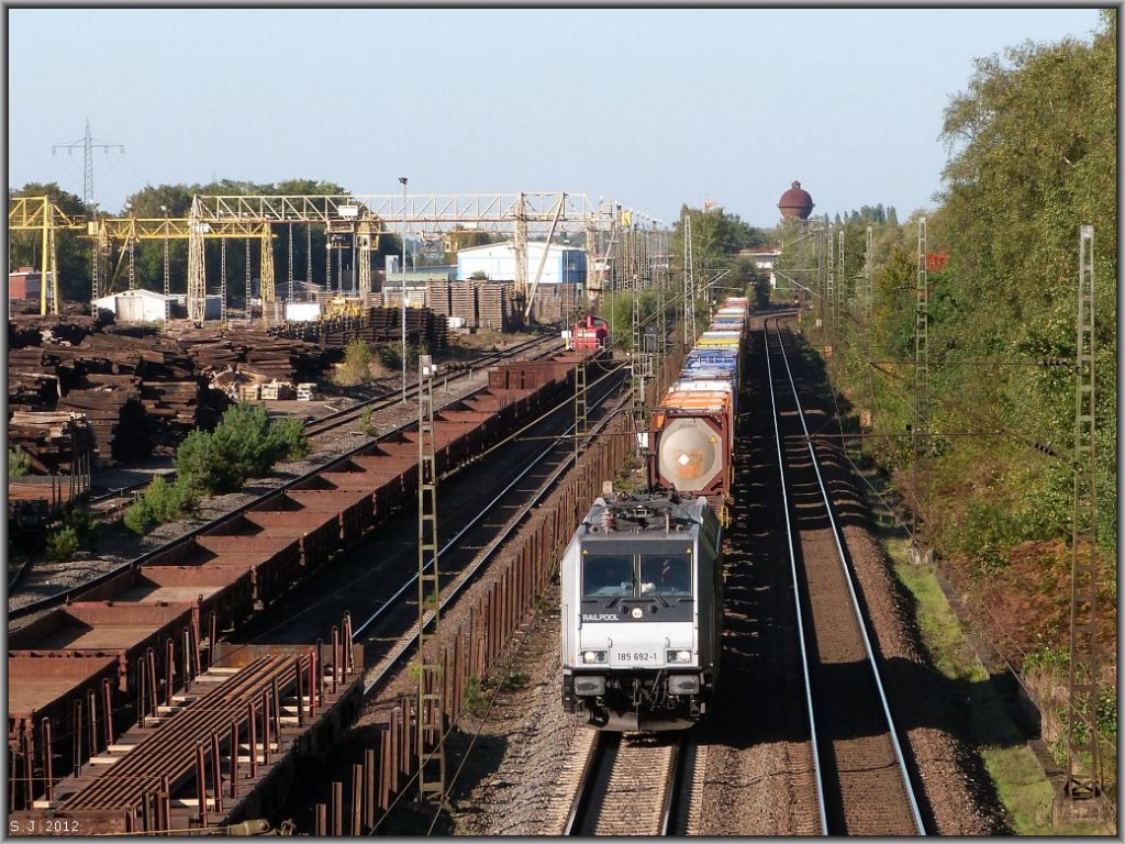 Unterwegs in Richtung Ratingen. Die 185 692-1 der Railpool mit schwerer Fracht am Haken f�hrt am Schienenlager bei Duisburg Wedau vorbei. Aufgenommen im Oktober 2012.