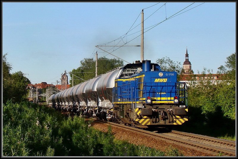 V2304 -MWB- vor einem Zementsilozug aus Mukran, verl�sst Stralsund in Richtung Rostock. am 14.05.09 (die Lok klebt  etwas  am Mast aber ich wollte unbedingt St Marien mit auf dem Bild haben)