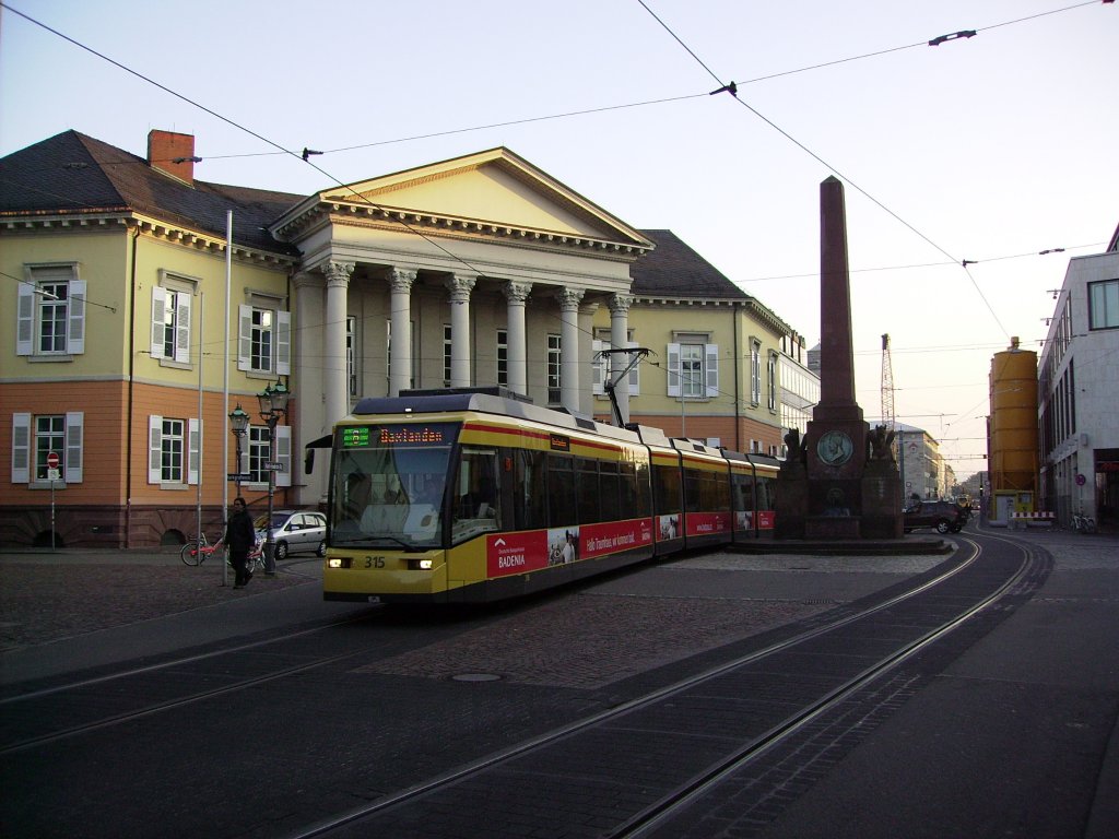 VBK Tw 315 ist, am 21.10.2011 als Straenbahnlinie 6 in Richtung Daxlanden unterwegs, als er beim Ettlinger Tor, die auf dem Rondellplatz befindliche Verfassungssule passiert.