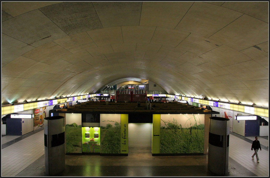 Verteilerebene in großer Gewölbehalle - 

Das Zwischengeschoß der RER-Station Auber liegt schon in großer Tiefe. Von hier gehen die Verbindungstunnel zu den Metrostationen Opéra (Linien 3, 7, 8), Havre Caumartin (Linie 3) und zur RER-Station Haussmann St-Lazare ab. Unter dieser Halle befinden die beiden Bahnsteige der RER A, darüber vermutlich der Streckentunnel der Metrolinie 3. 

21.07.2012 (M)