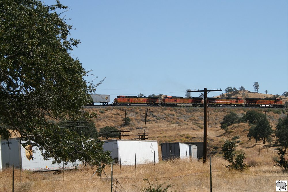 Vier Lokomotiven der BNSF, # 7368 (GE ES44DC), # 4080 (GE C44-9W), # 5232 (GE C44-9W)und # 4311(GE C44-9W), berqueren im Tehachapi Loop ihr eigenes Zugende. Leider ist der Zugang von unten durch Zune ziemlich versperrt, daher einer ehr bescheidene Aufnahme. Kalifornien, September 2011