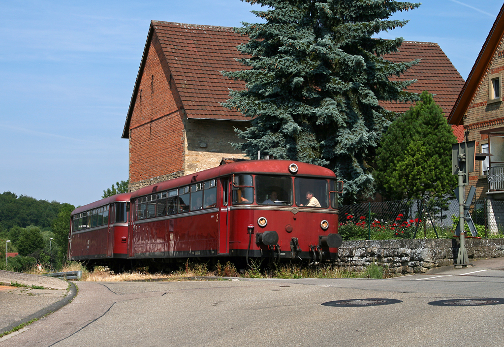 Vom 13. Juni bis zum 17. Oktober verkehrten auf der Krebsbachtalbahn an Sonntagen wieder Zge. Wo werktags frher die betagten MAN-Schienenbusse der SWEG Waibstadt im zuletzt sehr sprlichen Planverkehr (zwei Zugpaare pro Tag) eingesetzt wurden, kamen jetzt im Ausflugsverkehr (vier Zugpaare pro Verkehrstag) Uerdinger Schienenbusse der Pfalzbahn zum Einsatz.
Als RB 3013 von Neckarbischofsheim Nord nach Hffenhardt rollen 798 622 und 998 746 am 27. Juni 2010 in langsamer Fahrt durch die Ortschaft Obergimpern.