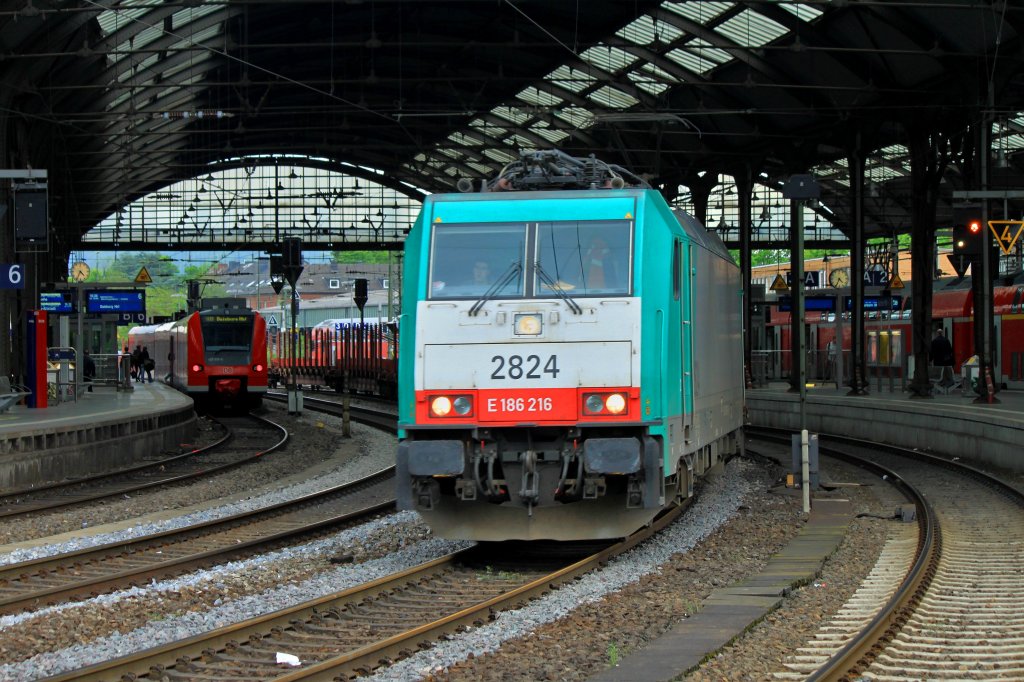 Von Aachen West kommend zieht Cobra 186 216 (2824) am 11.05.2012 einen leeren Drehgestellflachwagenzug mit Rungen durch den Aachener Hbf Richtung Kln.