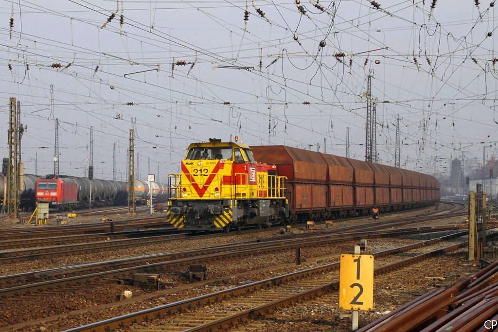 Von der Morgensonne beschienen zieht Lok 212 der MEG am 5.3.2011 den leeren Kohlependel durch Grokorbetha.