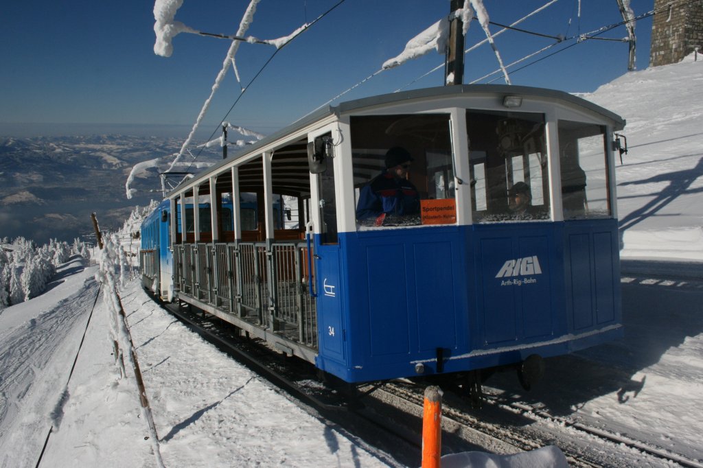 Vor einem weiten Ausblick auf das frisch verschneite Luzerner Hinterland rollt der Schlittelwagen 34 zusammen mit Triebwagen 14 als Leerzug vom Rigi-Kulm talwrts Richtung Staffel und Klsterli. 20.12.2009. 