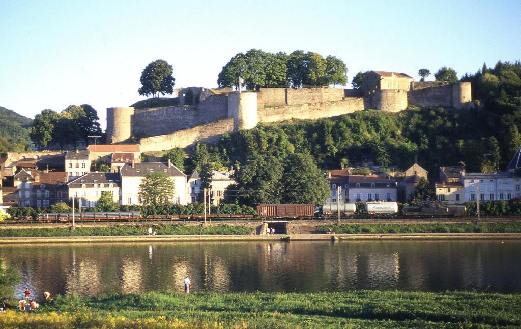 Vor der Festung in Sierck le Baines an der Mosel fhrt ein unbekanntes SNCF Krokodil
mit einem Gterzug am 7.4.1996 Richtung Frankreich vorbei.