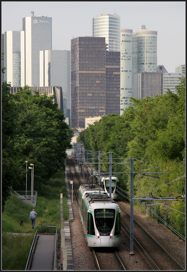 Vor Hochhauskulisse - 

Zwei Züge der Linie T2 begegnen sich vor der Kulisse der Bürostadt La Défense nördlich der Station  Belvedère . 

21.07.2012 (M)
