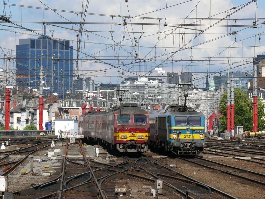 Vor der Kulisse der Brsseler City kreuzen sich im Vorfeld von Bruxelles-Midi die einfahrende 2131 mit ihren M4-Wagen und der ausfahrende Triebwagen 820 der Serie AM75. Diese Triebwagen bestehen aus 4 Elementen mit 358 Pltzen (gegenber 2 bei den lteren Serien), um dem damals immer grsser werdenden Verkehrsaufkommen gerecht zu werden. Aufgenommen am 17/09/2010 vom Bahnsteig 10.