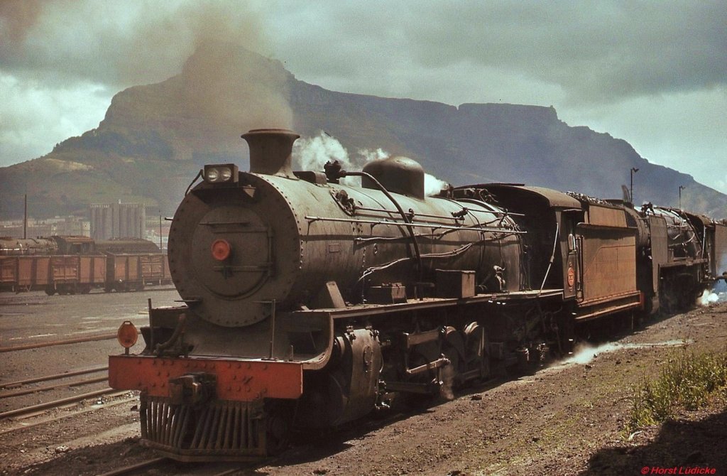 Vor der Kulisse des Tafelberges stehen eine 14CRB und eine 15F im Depot Paarden Eiland/Kapstadt. Im November 1976 neigte sich hier die Dampflokzeit bereits ihrem Ende entgegen, die Maschinen wurden nur noch für Übergaben und Rangierdienste benötigt