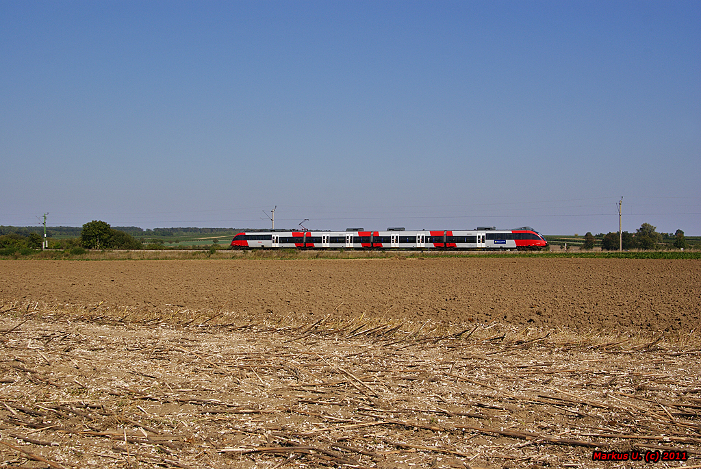 Vorbei an abgeernteten Feldern fhrt 4124 035 als REX2824 nach Wien Meidling. Deutschkreutz, 27.09.2011