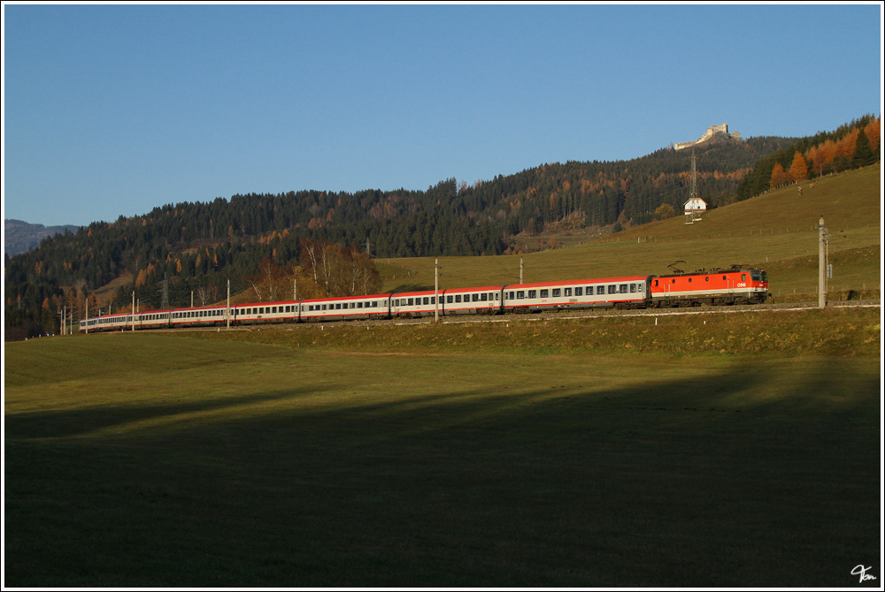 Vorbei an der Burg Ruine Steinschloss, zieht 1044 034 den IC 733  Sonnenstadt Lienz  von Wien Meidling nach Lienz. 
Neumarkter Sattel nahe Mariahof 12.11.2011