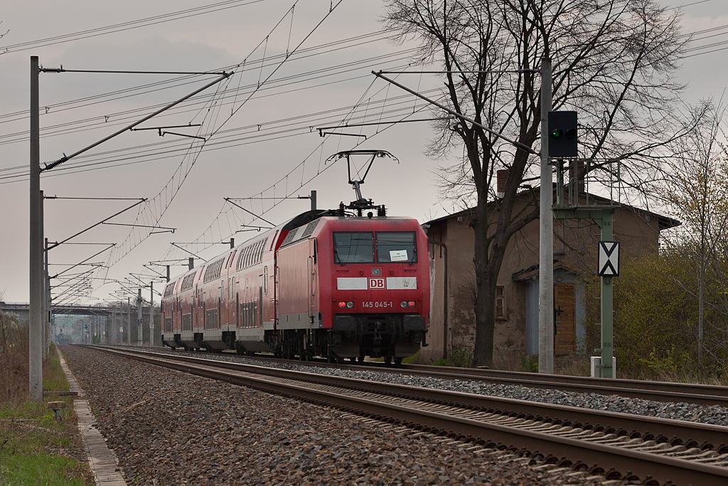 Vorbei an einem verlassenen Bahnw�rterhaus schiebt 145 045 einen Regionalexpress in Richtung Oschatz. (bei Bornitz am 15.04.2012)