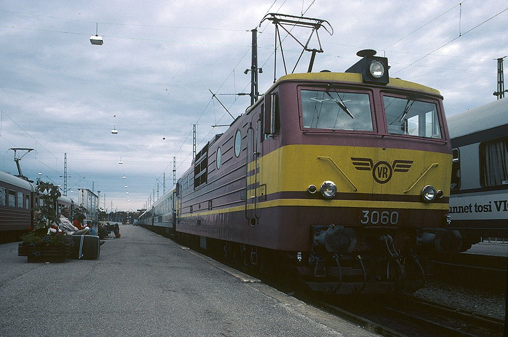 VR Sr1 3060 mit damaligem Farbkleid vor Fernreisezug. An den Ort kann ich mich nicht mehr erinnern. Gemss eMail-Zuschrift entstand das Foto in Helsinki Hbf. Juli 1982, HQ-Scan ab Dia.
