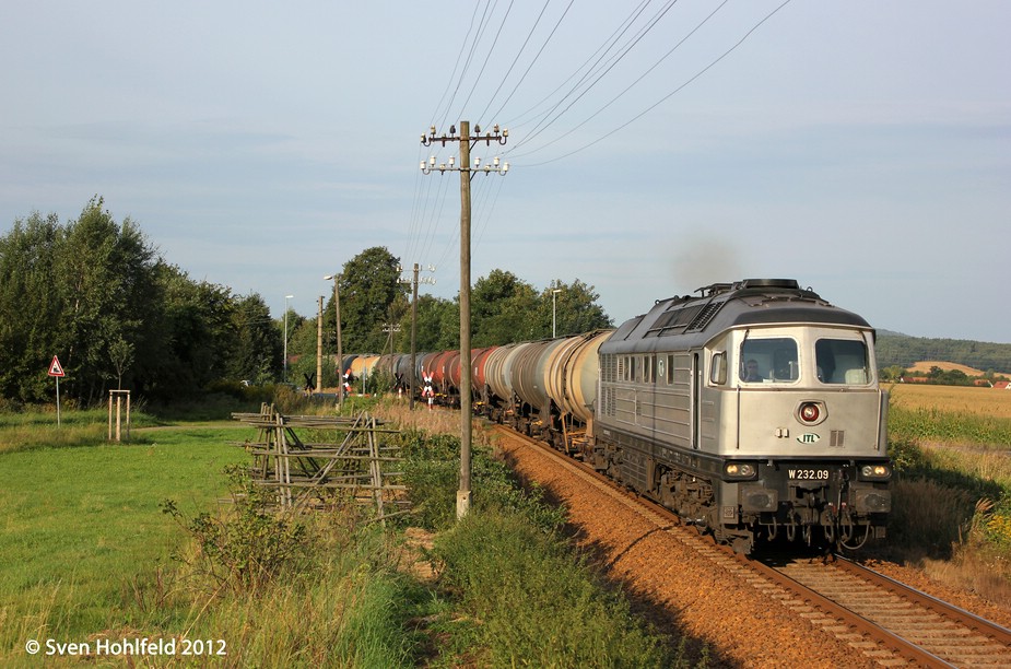 W232.09 der ITL wuchtet im Morgenlicht des 30.08.2012 einen Kesselzug aus Bischheim-Gersdorf heraus gen Kamenz. Am Schluss, nicht sichtbar, schieben noch 293.01 + 293.02 der ITL nach. 