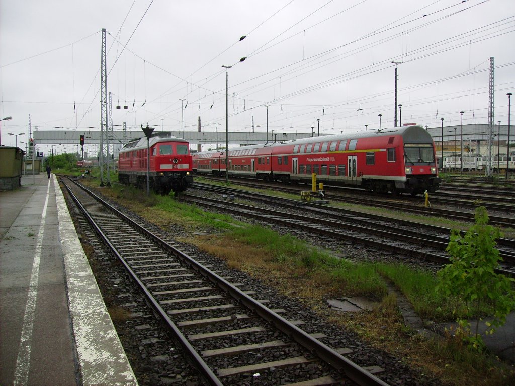 Whrend eine 232 auf einem Nebgleis abgestellt ist, rckt im Sommer 2009 ein RE mit alten Doppelstockwagen aus der Abstellgruppe des Bahnhofs Berlin Lichtenberg aus.
