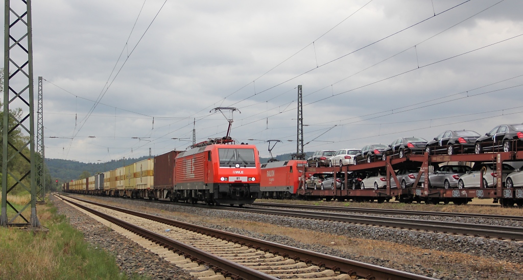 Whrend der Autozug in Richtung Norden noch am Signal warten muss, rauscht 189 801-4 mit der  Bierkiste , dem Warsteiner-Zug, in Richtung Sden durch Mecklar. Aufgenommen am 15.07.2011