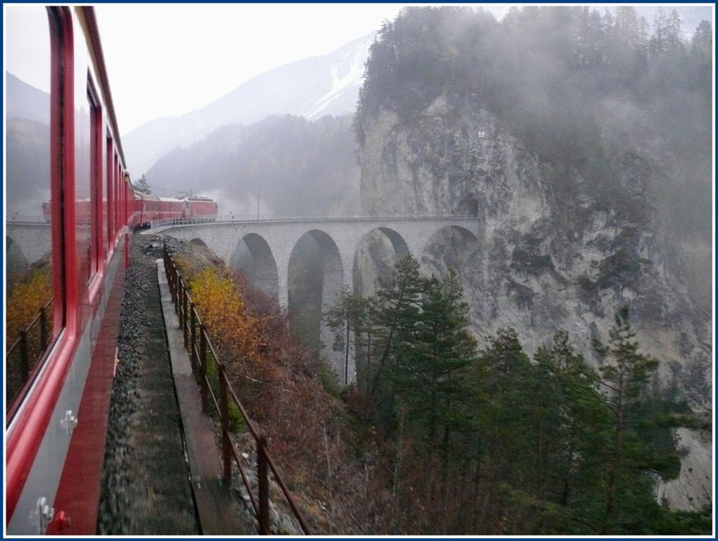 Whrend jenseits des Albulatunnels eitel Sonnenschein herrscht, ist es auf der Nordseite trb und neblig. R1117 wird von der Ge 4/4 III 651  Fideris  soeben auf den frisch renovierten Landwasserviadukt gezogen. (11.11.2009)