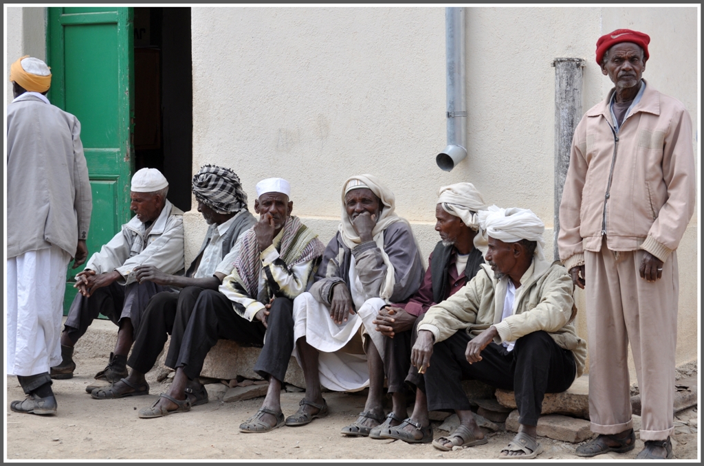 Whrend die Jugend steht, haben es sich die Dorfltesten bequem  gemacht am Bahnhof Arbaroba. Man beachte die Einheitsgummisandalen. (02.02.2012)