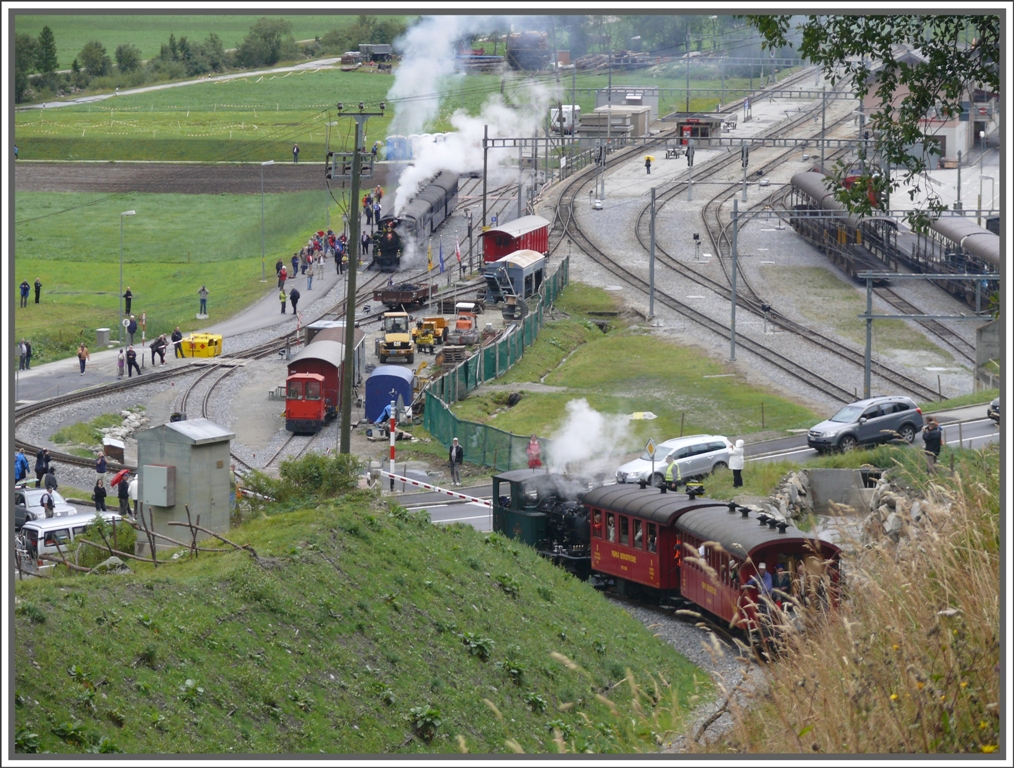 Whrend Lok 7 die Hauptstrasse (mittels versenkbarer Zahnstange) berquert, wartet auf Gleis 6 bereits Lok 4 fr die anschliessende Bergfahrt nach Gletsch. Rechts sind die Geleise der MGB und der Autoverladebahnhof Oberwald zu sehen. (15.08.2010)