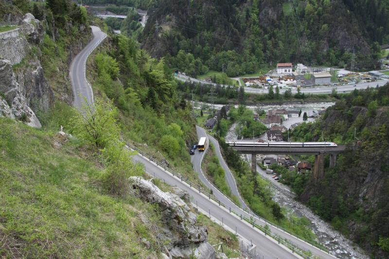 Whrend das Postauto sich ber den Kurs Amsteg-Bristen-Golzern Seilbahn windet, berquert ein ICN die Kerstelenbachbrcke; 02.05.2010