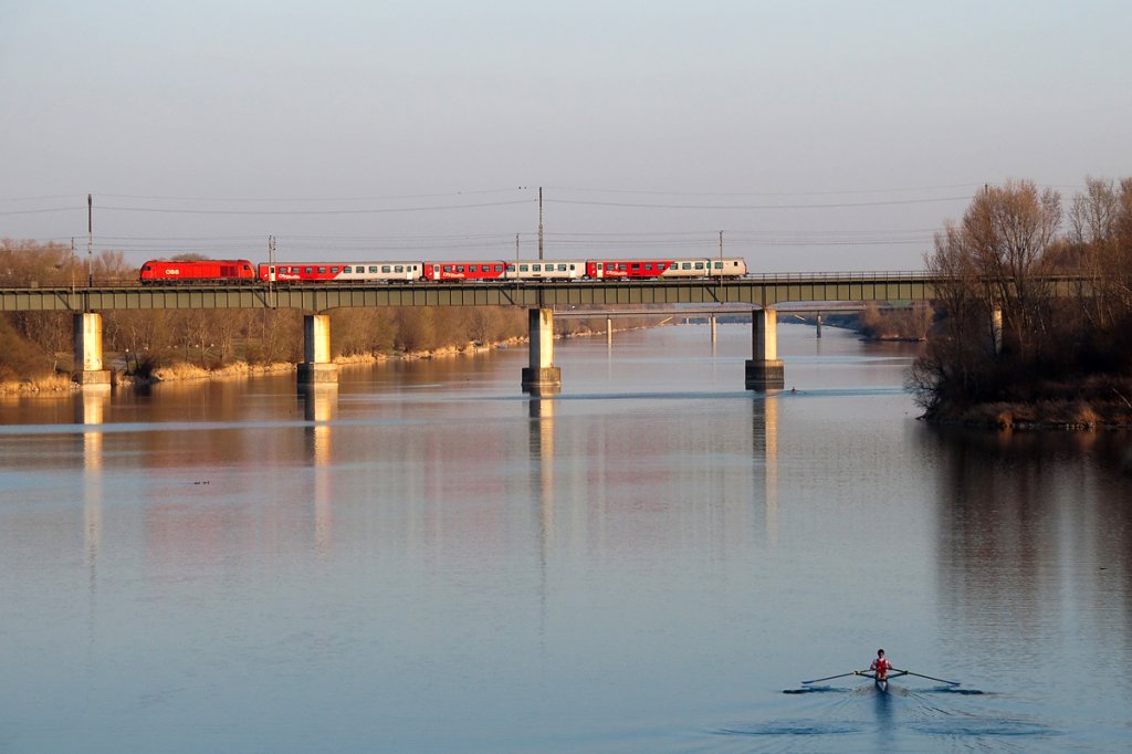 Whrend der Regionalzug 2582 nach Marchegg ber die Ostbahnbrcke rollt, legt sich der Ruderer im Vordergund nochmals ordentlich ins Zeug. Die Aufnahme entstand am Abend des 21.03.2012.