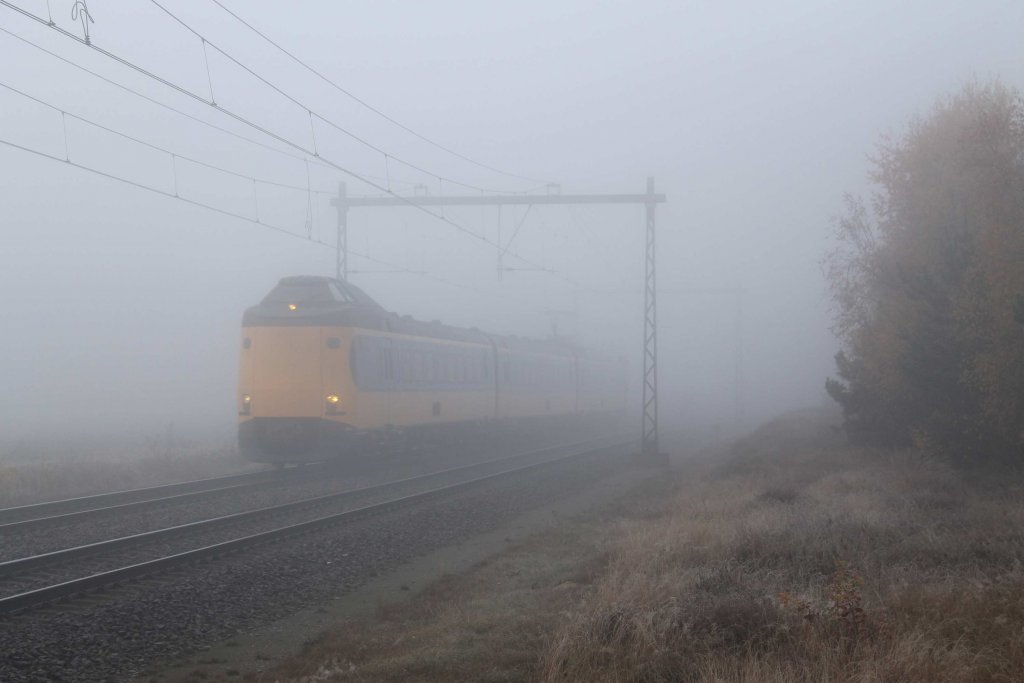 Whrend sehr trbes und nebliges Wetter fahrt einem Koploper mit IC 1625 Schiphol-Enschede bei Holten am 19-11-2012.