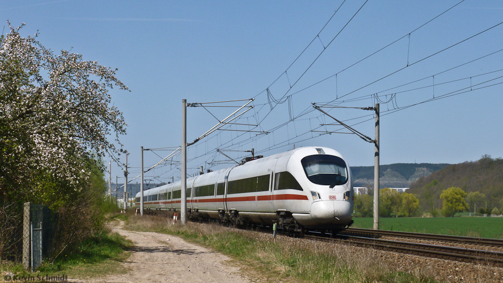 Während sich der Frühling mit dem Baum links im Bild schon von seiner schönsten Seite zeigt, hat ICE 1611 von Warnemünde nach München eben Jena verlassen und durchfährt in Kürze den Haltepunkt Rothenstein (Saale). (28.04.2012)