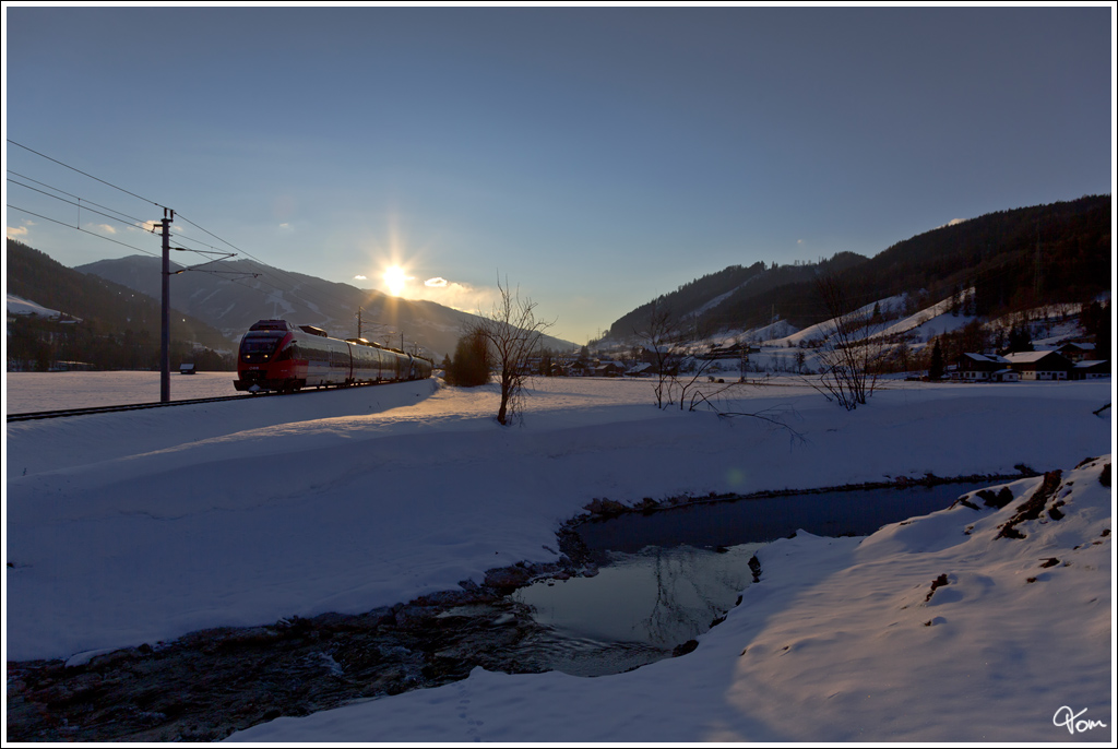 Whrend die Sonne ber der Planai untergeht, fahren 4024 102 + 4024 128 als Shuttlezug SR 9321 bei der Alpinen Ski WM 2013 in Schladming , von Schladming nach Haus im Ennstal.  
Schladming 10.2.2013