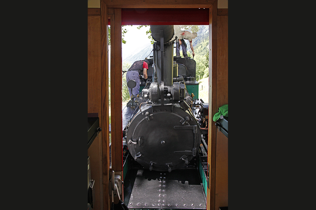 Whrend unserer Kaffeepause reinigen BRB-Lokfhrer Kurt Amacher und Heizer Tim Hess die kohlenbefeuerte Lok 5. Dann geht's in Brienz unten nur noch um den Finish. Kreuzungsstelle Geldried, durch die Tr des B27 am 16. Juli 2012, 13:40