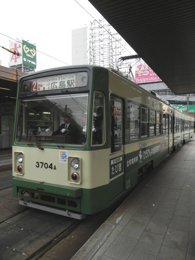 Wagen 3704 der Strassenbahn Hiroshima als Linie 2 bei der Einfahrt in die Endhaltestelle JR Hiroshima Station am 11.11.2010. Die hier endenden Zge lassen auf diesem Bahnsteig die Fahrgste aussteigen und fahren dann auf das jeweilige Stumpfgleis und machen dort kehrt, um in die entgegengesetze Richtung wieder auszufahren.