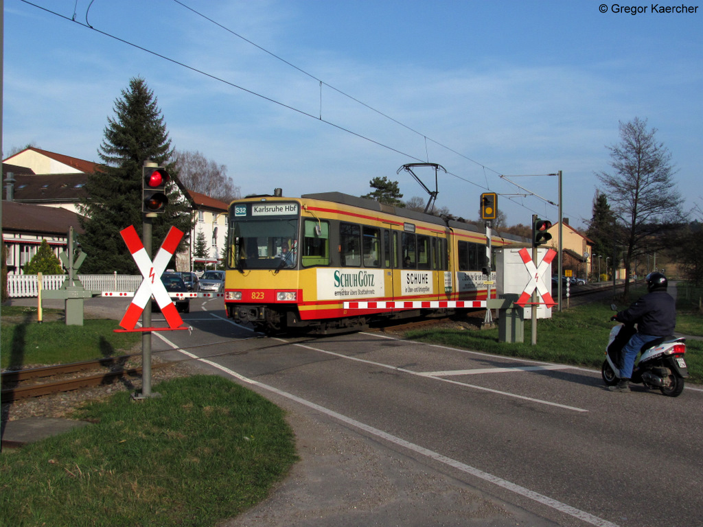 Wagen 823 mit Werbung von Schuh Gtz passiert den Bahnbergang Neuenwegstrae in Oberwisheim.