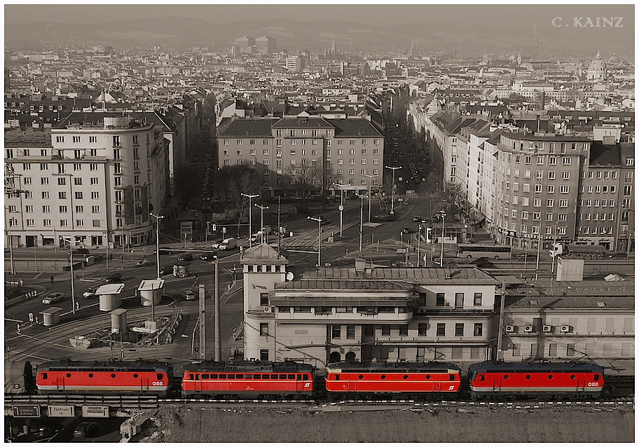 Was in der Nacht mit Gterzgen nach Sden und Westen rollt, muss tags darauf auch wieder zurck in den Osten kommen, wo sich mit dem Wiener Zentralverschiebebahnhof Kledering die Gterverkehrsdrehscheibe des Landes befindet, und wo die Maschinen fr die Folge-Nacht erneut schon wieder dringend bentigt werden. Da aber gelegentlich mehr Zge von Wien weg als nach Wien zurck verkehren, und Gterzugumlufe manchmal unpaarig sind, werden solche Maschinen, fr die es keine Retourleistung gibt, bei Bedarf in Lokzgen oder mit anderen Planzgen zurckgefhrt. Meistens ist es dann eben eine zweite Lok, die kalt im Zugverband mitluft. Dagegen ist ein Gterzug, der mit vier Maschinen kommt, schon eine kleine Sensation. berhaupt. wenn sich mit 1144.040 und 1042 041, die letzte blutorange 44er und eine der letzten noch vorhandenen 1042er im Zugverband befindet. Die Aussicht, diesen Zug vor dem alten Sdbahnhof - Stellwerk ber den Dchern von Wien zu fotografiern, veranlasste mich zur Erstbesteigung des 66m hohen Bahnorama - Turmes, der nicht nur der hchste Holzturm Europas ist, und interessierten Besuchern einen grossartigen Ausblick ber das 109 Hektar grosse Areal der Hauptbahnhof - Baustelle gewhrt, sondern schwindelfreien Fotografen, viele fantastische Motive mit abwechslungsreichen Zgen ber den Dchern von Wien erffnet … 