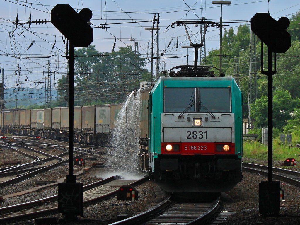 Wasserspiele 1: Bei einem heftigen Regenschauer sammelt sich Wasser auf den Planen der Wechselbrcken, die nun  beim Gleiswechsel auf die Montzenrampe abgeschttet werden. Cobra 186 223 (2831) zieht am 10.07.2012 den Ambroggio Ganzzug aus Aachen West nach Belgien. 