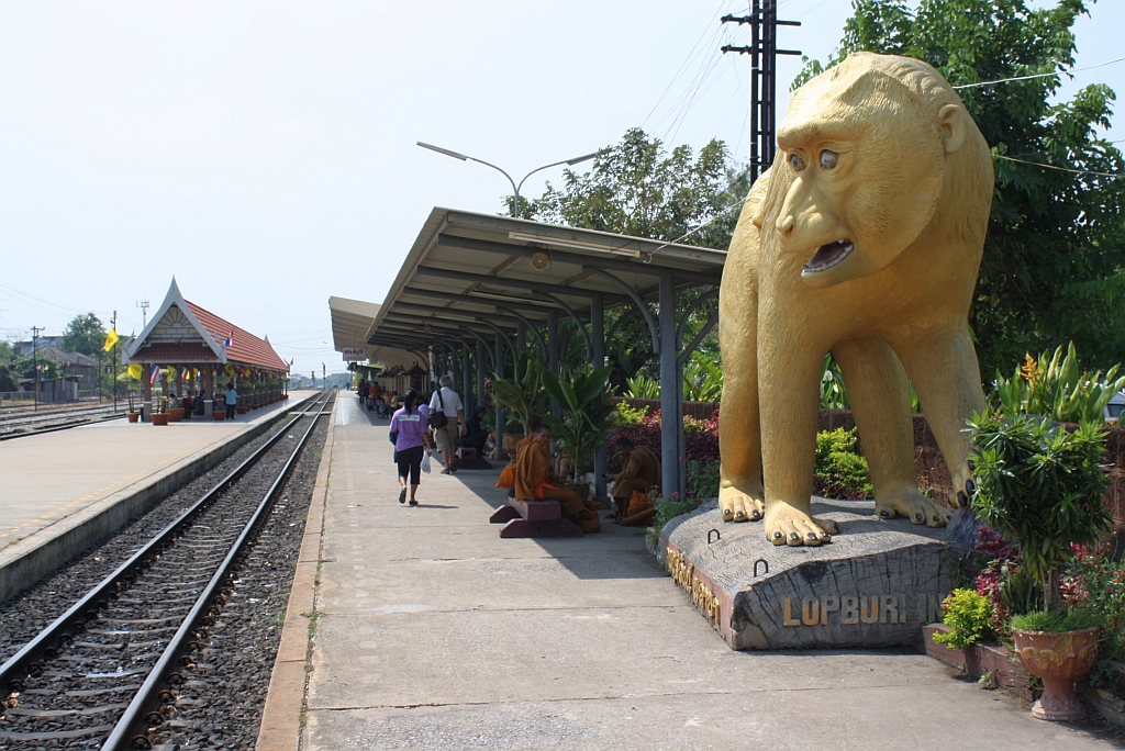 Wegen der dort frei lebenden Affen trägt Lopburi auch den Beinamen  Stadt der Affen . Man begegnet diesen Tieren überall in der Stadt, nicht nur als lebende Wesen sondern auch als Skulpturen. So hat man diesen Tieren auch auf dem Hausbahnsteig der Lopburi Station ein Denkmal gesetzt. Bild vom 13.März 2012.

