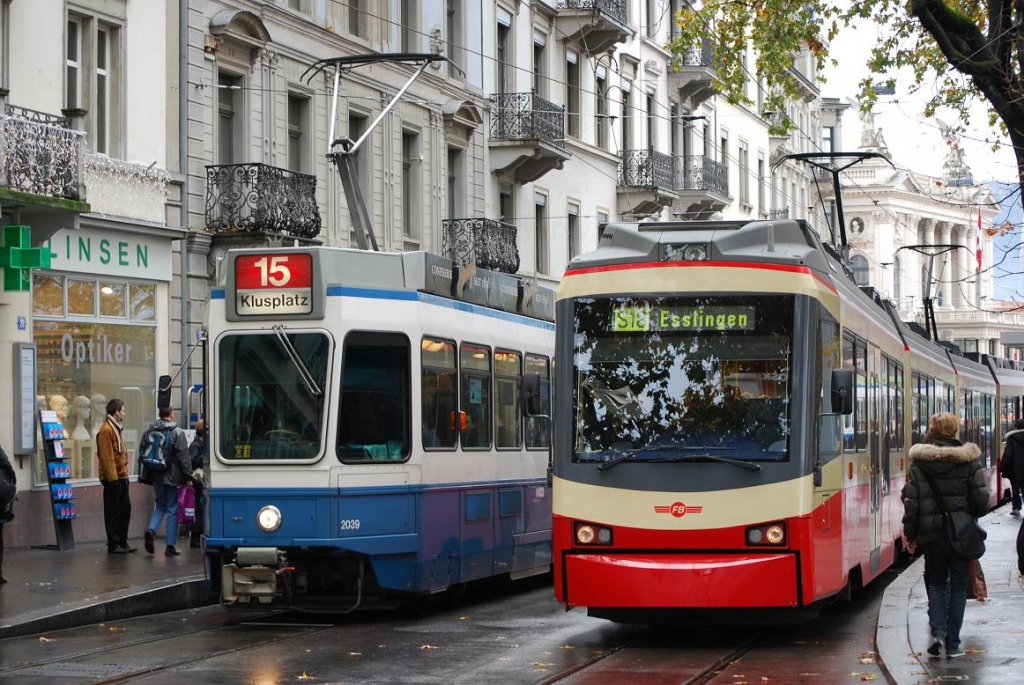 Wer in Zrich Stadelhofen mit der S18 weiterfahren will, sollte nicht am Bahngleis warten, sondern sich vor dem Bahnhof zur Straenbahn begeben. Die meterspurige Forchbahn nimmt die Fahrgste als S18 hier auf Straenbahngleisen auf. Im Bild wartet am 16.11.09 der Stadler Be 4/6 der Forchbahn neben dem Be 4/6 2039 ( Tram 2000 der ersten Bauserie )der Zrcher Straenbahn (VBZ) auf Fahrgste Richtung Esslingen.