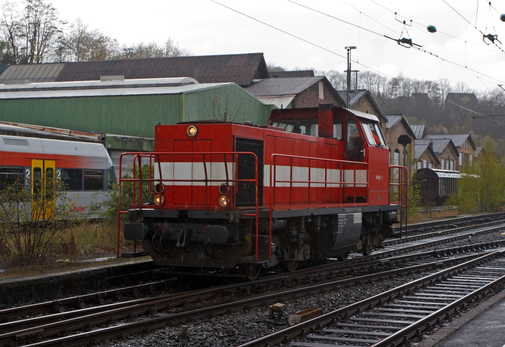 Westerwaldbahn (WEBA) Lok 5 (DH 1004) rangiert im Bf. Betzdorf/Sieg, hier im Regen am 24.04.2012. Die Urspungslok ist die DB V100 1177 (ab 1968 DB 211 177-1) welche 1961 von Henschel unter der Fabriknummer 30526  gebaut wurde. 1998 erfolgte der Umbau durch Vossloh nach dem Konzept von On Rail mit Serienteilen der Type G1205 unter Verwendung von Rahmen und Drehgestellen in die DH 1004. Sie besitzt einen MTU 12V396TC14 Motor mit 1.030 kW (1.400 PS) Leistung.