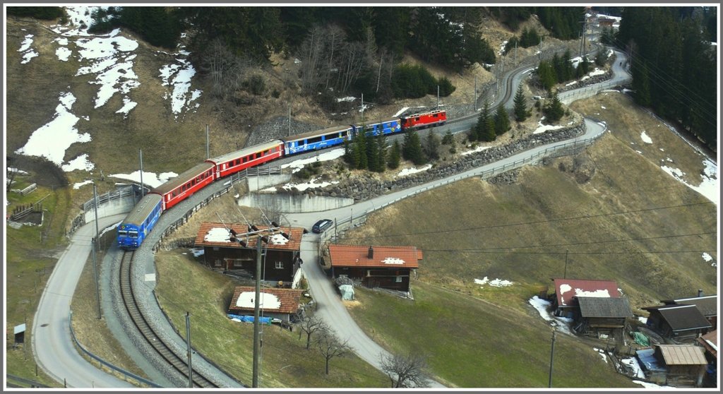 Wie eine Modelleisenbahn kurvt der R1444 unterhalb Langwies um die Bauernhuser. (25.03.2010)