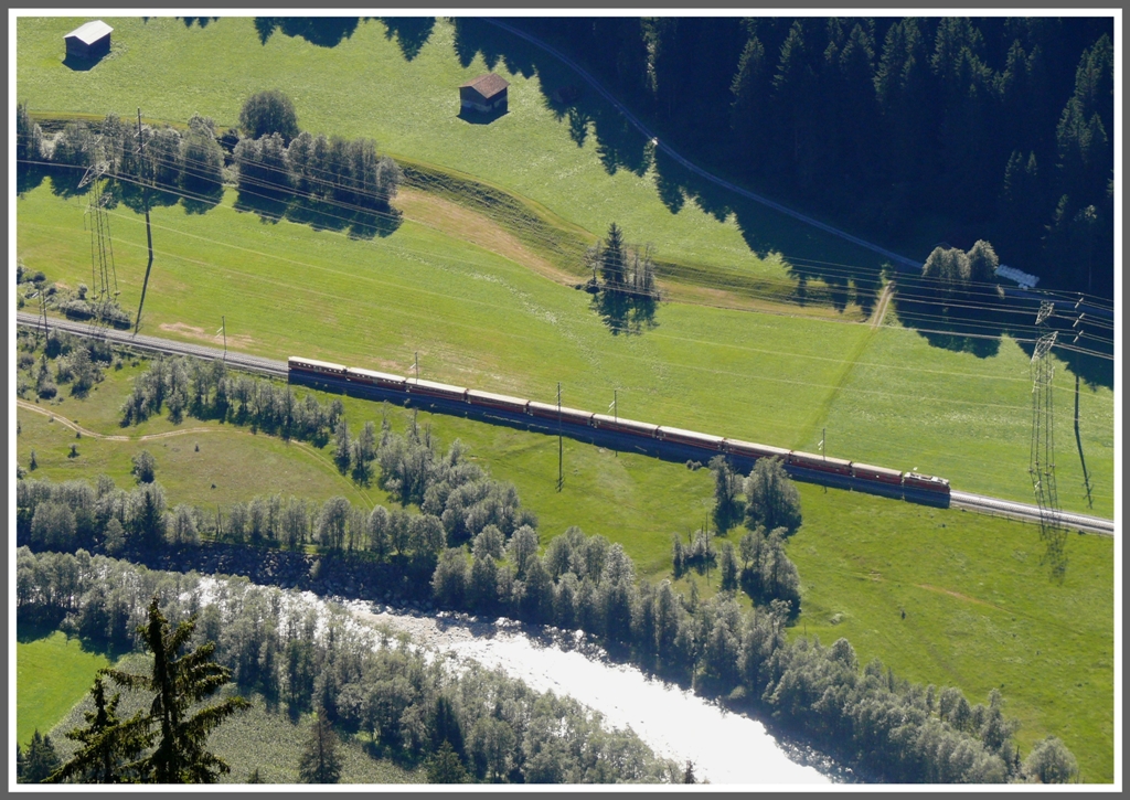 Wie eine Modelleisenbahn wirkt der RE1220 vom Hgel Flanz 1328m herunter gesehen. Der Zug befindet sich auf 754m beim Bahnhof Waltensburg/Vuorz. (28.08.2011)
