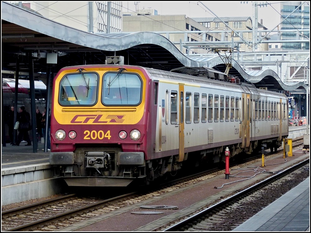 Wie zusammengestaucht sieht das wellenfrmige Bahnsteigdach im Bahnhof von Luxemburg aus, als der Triebzug 2004 am 08.02.2011 davor posiert. (Jeanny) 