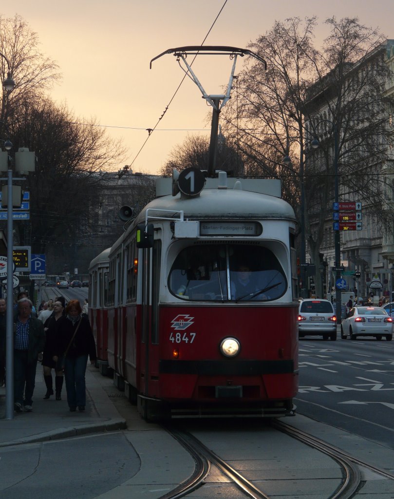 Wiener Straenbahn (E1 4847) der Linie 1 Richtung Stefan-Fadinger-Platz hat die Haltestelle Oper verlassen und biegt nun in die Krtner Strae ein. 24.03.2012