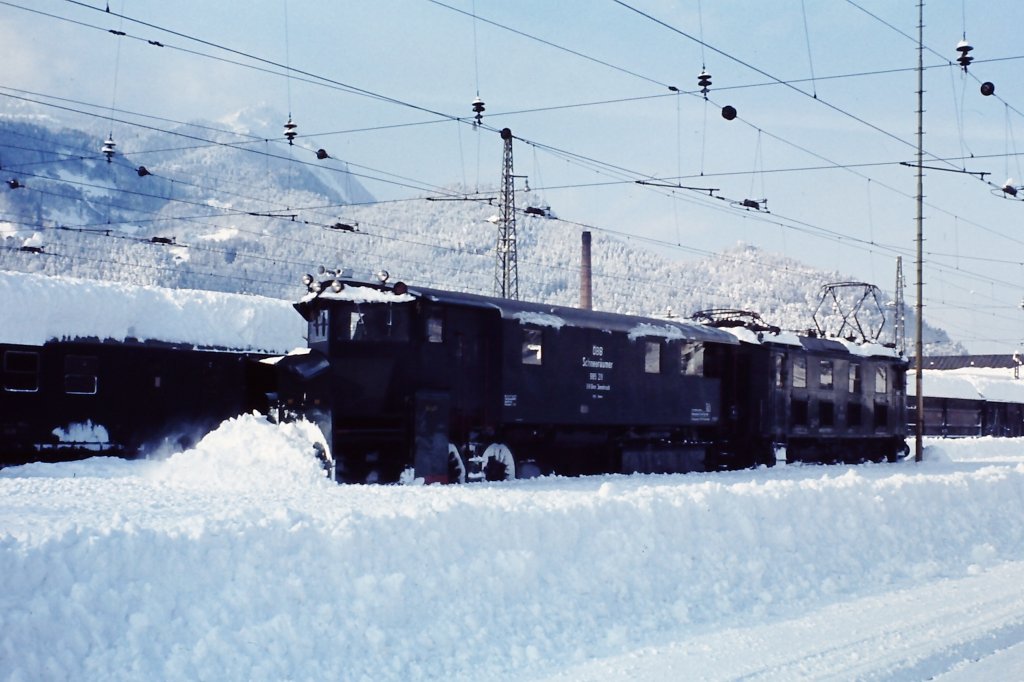 Winterdienst am 16. Dezember 1976 im Bahnhof Bludenz mit Schneepflug, geschoben von einer 1180. Der auf das Nachbargleis geschobene Schnee wurde anschlieend von der Dampfschneeschleuder hinausbefrdert. 